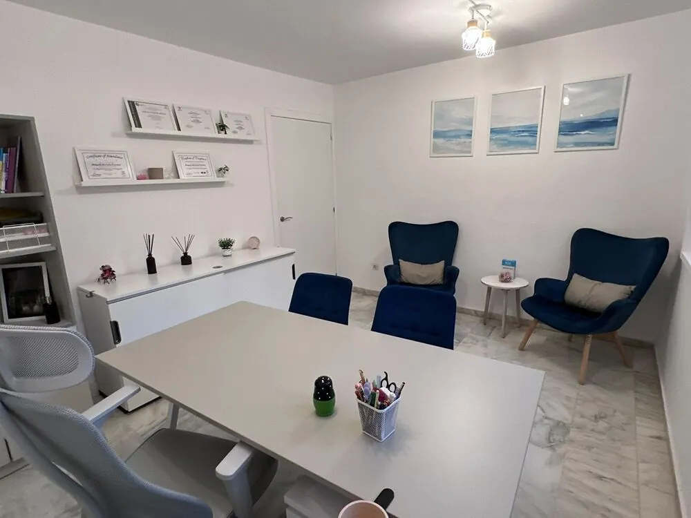 Consulta con mesa, butacas y estanterías con certificados